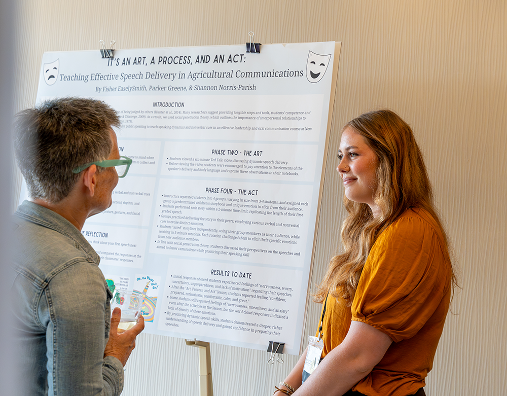 A student presents her poster at the 2023 ACE conference in Asheville to a conference planning committee member. 